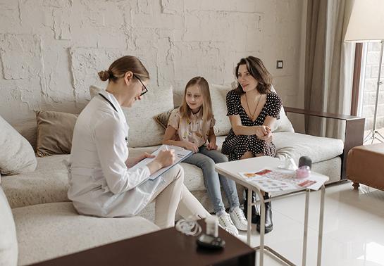 Médica em consulta domiciliar com paciente e família